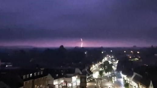 Lightning in dark sky over town
