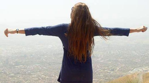 A woman standing on the top of a hill with her back to the camera and her arms outstretched - one of the images of the "My Stealthy Freedom" Facebook page