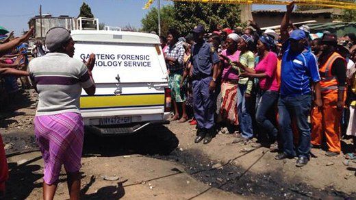Angry Diepsloot residents gathered around a police forensics vehicle, South Africa - Tuesday 15 October 2013