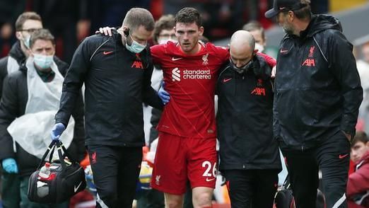 Andy Robertson is helped from the pitch by medical staff