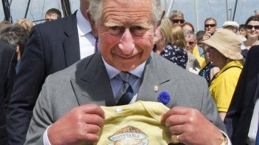 Prince Charles is given a present for his grandson Prince George of Cambridge at the Whitstable Oyster Festival