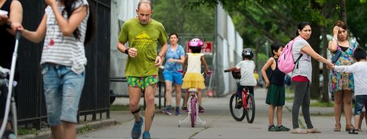 A competitor runs through pedestrians in the Sri Chinmoy Self Transcendence 3,100 Mile Race