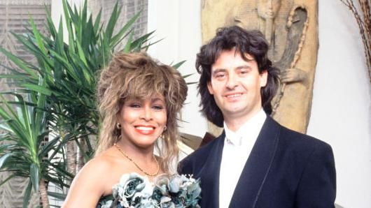 Tina Turner and Erwin Bach in a suit and dress at Turner's 50th birthday party