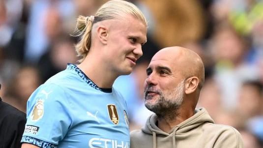 Erling Haaland talks with Manchester City boss Pep Guardiola during the win against Ipswich