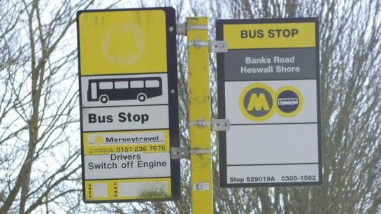 A pair of yellow, black and white bus signs at the Banks Road bus stop, with an image of a bus and the Merseytravel logo on them