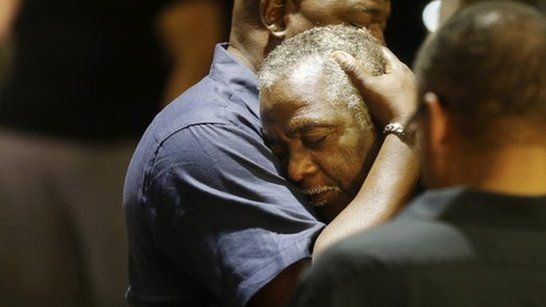 Men embrace near the site of a church shooting in South Carolina