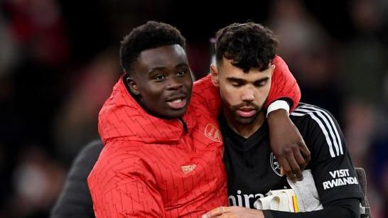 Arsenal player Bukayo Saka with his arm around David Raya 