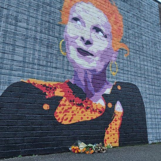 Flowers left by the mural to Vivienne Westwood