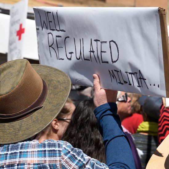 A gun control advocate holds a handmade sign with quoting a portion of the U.S. Constitution's Second Amendment at a 'March For Our Lives' rally in Santa Fe, New Mexico