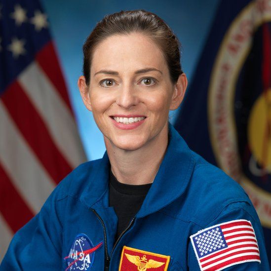 Nicole Mann poses for here formal Nasa photo in kit