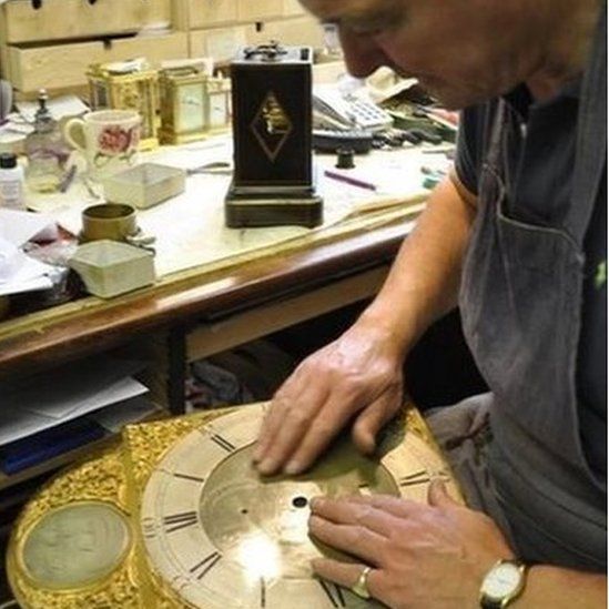 Mark Sampson holding a clock