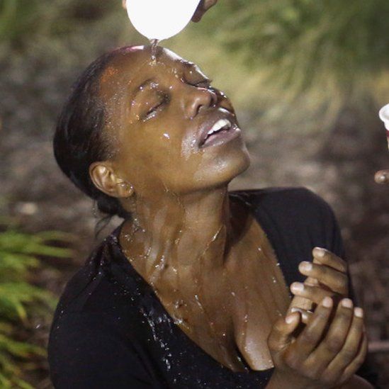 A Ferguson woman has water poured in her eyes to try to get rid of the tear gas