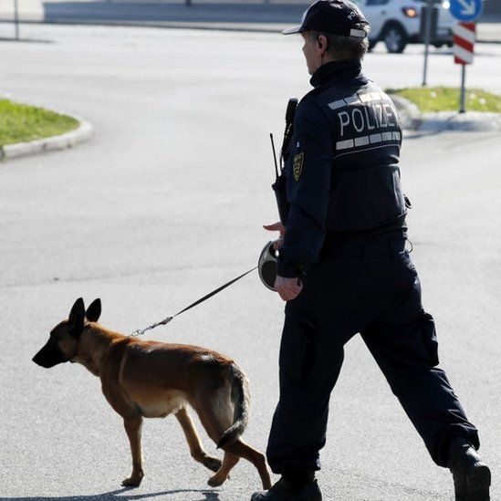 A police officer with his dog patrols in a street near the site where a suspect in the bombing attack on team bus of Borussia Dortmund was arrested, in Rottenburg (21 April 2017)
