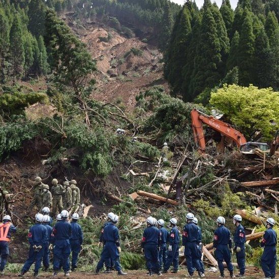 Soldiers and rescue workers examine a landslide site in the aftermath of two earthquakes in Minami-Aso, Kumamoto prefecture (17 April 2016)