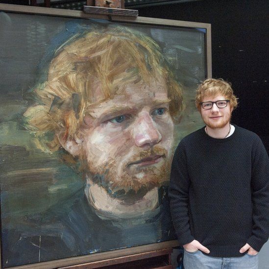 Ed Sheeran stands beside his portrait by Colin Davidson