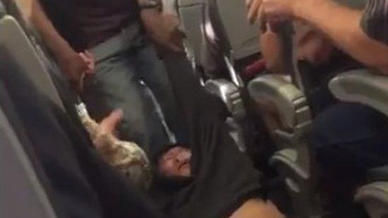 The passenger believed to be a doctor is shown in a video being dragged out of his seat by flight security