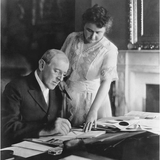 First Lady Edith Wilson assists President Woodrow Wilson at his desk in the White House, Washington DC, June, 1920