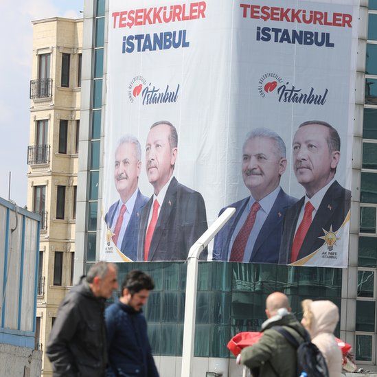People pass in front of a huge banner with pictures of Turkish President Recep Tayyip Erdogan and Binali Yildirim, candidate of Turkish ruling party Justice and Development Party (AK Party) reading on "Thank you Istanbul" in Istanbul, Turkey, 03 April 2019