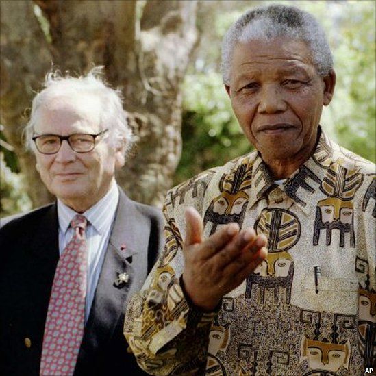Nelson Mandela asks journalists what they think of his shirts after a lunch with fashion designer Pierre Cardin