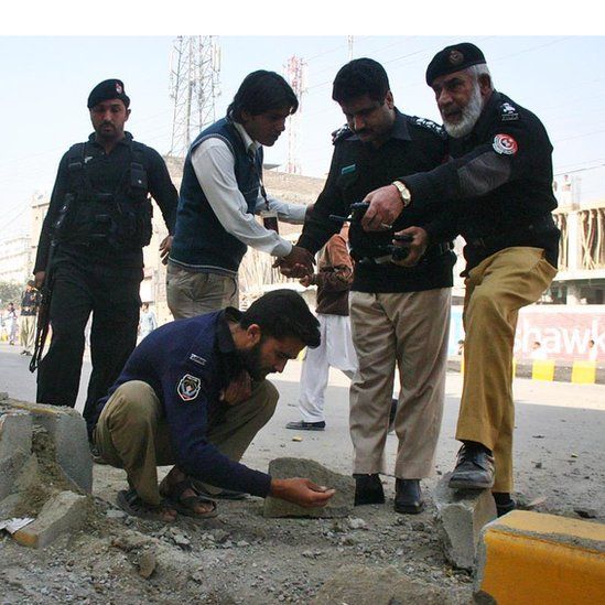 Bomb disposal experts examine the evidence after a bombing