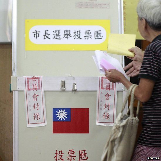 A woman casts her ballot at a voting station during local elections in Taipei. Photo: 29 November 2014