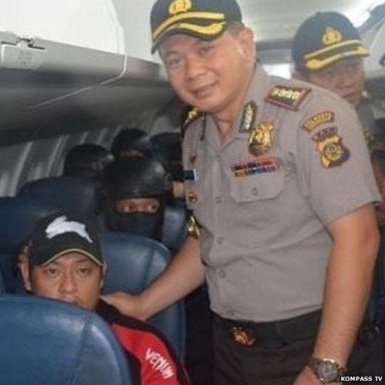 Indonesian policeman Djoko Hari Utomo poses smiling with Andrew Cha