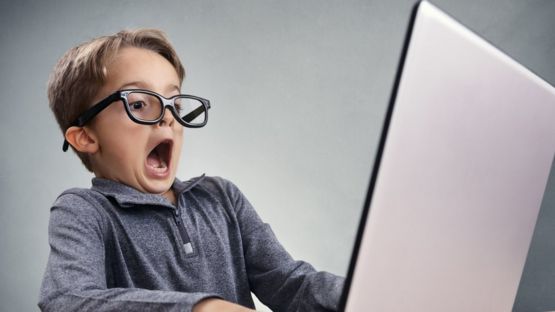 Niño en frente de una computadora.