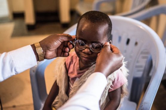 Un doctor le pone los lentes a Criscent por primera vez.