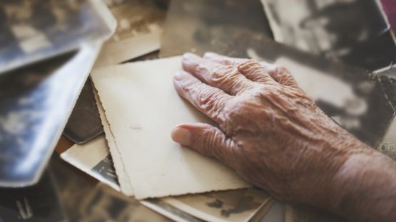 Mano de anciano sobre fotos antiguas