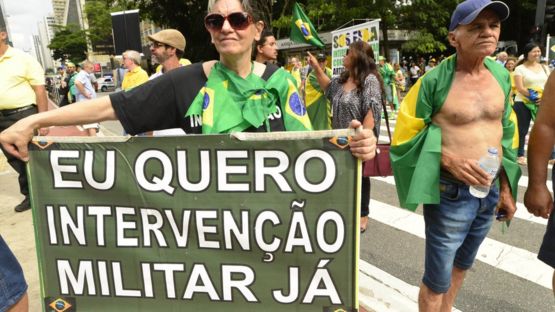 Mujer con cartel que pide intervención militar en Brasil