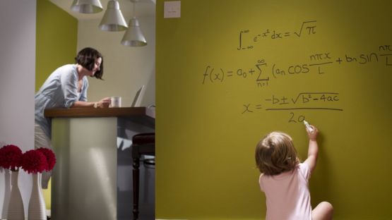 Niña escribiendo en una pared.