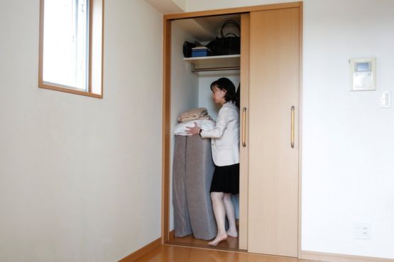 La minimalista Saeko Kushibiki guarda su futón en su apartamento en Fujisawa