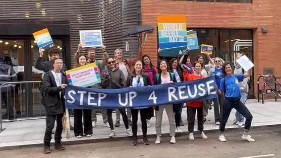 A group holding a banner saying step up to reuse