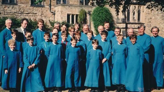 Three rows of mixed-aged males dressed in blue gowns