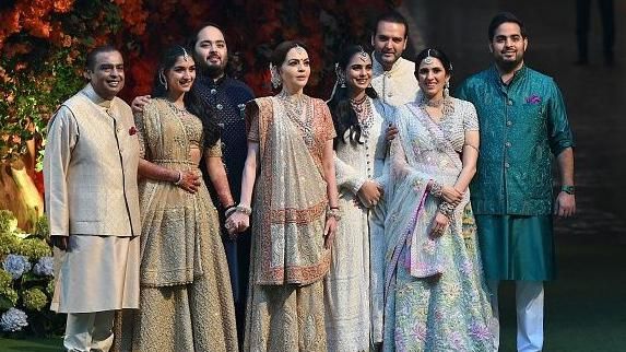 Indian billionaire Mukesh Ambani (L) along with his wife Nita (4L) pose with their elder son Akash (R) his wife Shloka (2R), daughter Isha (4R) her husband Anand Piramal (3R) and younger son Anant (3L) his fiancée Radhika Merchant (2L) during Anant's engagement ceremony in Mumbai on January 19, 2023.