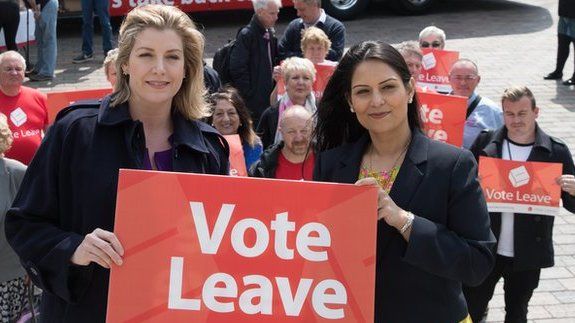 Vote Leave campaigners with a campaign bus behind them that says "We sent the EU £350 million a week"