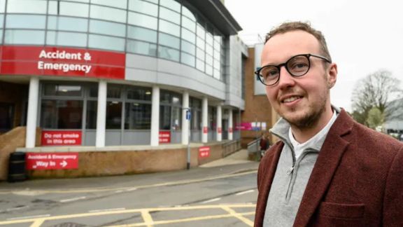 Adam Dance standing in front of an A&E department