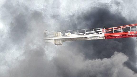 A person on a crane surrounded by smoke