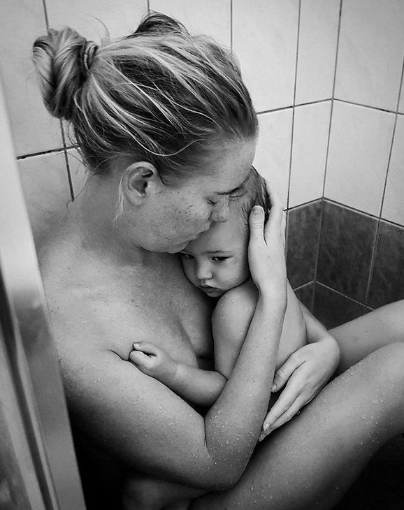 Kelli Bannister holding her daughter in the shower