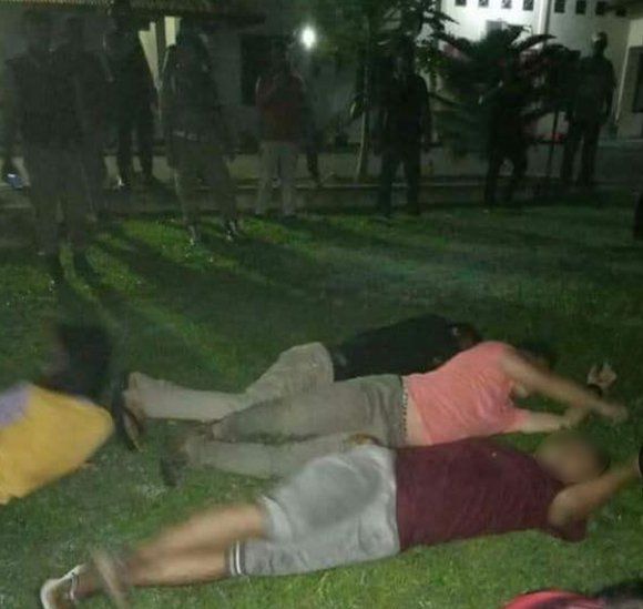 The transgender women lying on the floor, surrounded by police officers, after being arrested