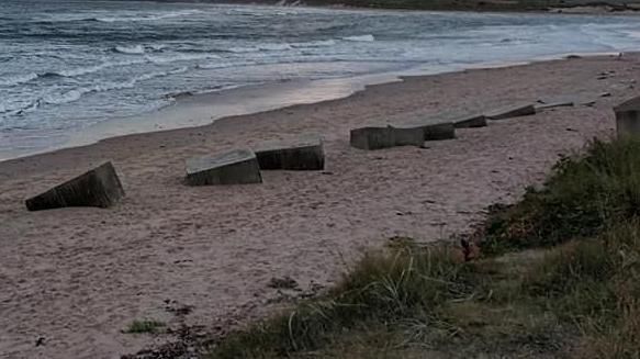 A row of tank traps buried deep in the sand