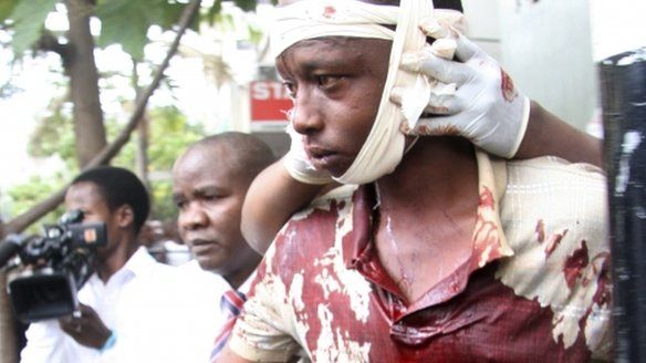 A man injured during an explosion is assisted from the scene in Kenya's capital Nairobi, May 28, 2012.