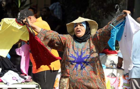 A woman sells clothes at a street market in Cairo