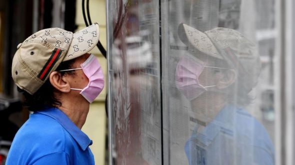 Man reading newspaper in Hanoi