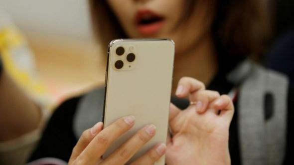 Một phụ nữ dùng iPhone 11 Pro Max ở Bắc Kinh