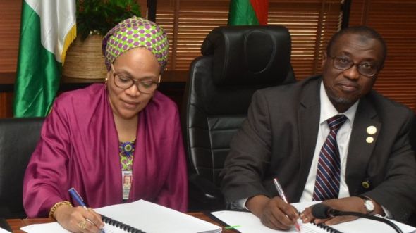 Shugaban kamfanin mai na Najeriya, NNPC, Dokta Maikanti Baru (daga dama) lokacin da yake rattaba hannu a kan kwangilar shimfida bututan gas