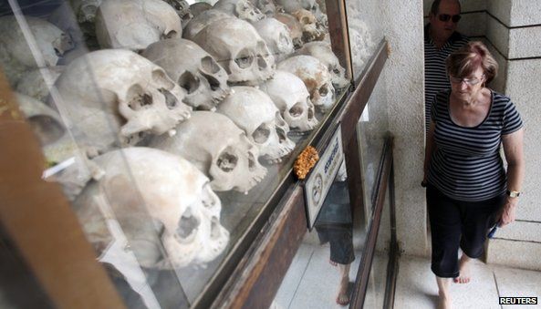 Tourists visit at a memorial stupa with bones of more than 8,000 victims of the Khmer Rouge regime at Choeung Ek, a "Killing Fields" site located on the outskirts of Phnom Penh