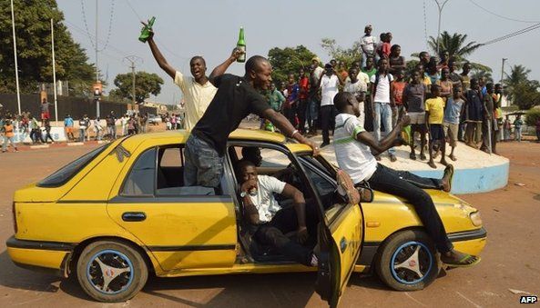 People celebrate in Bangui after the announcement of the resignation of President Djotodia