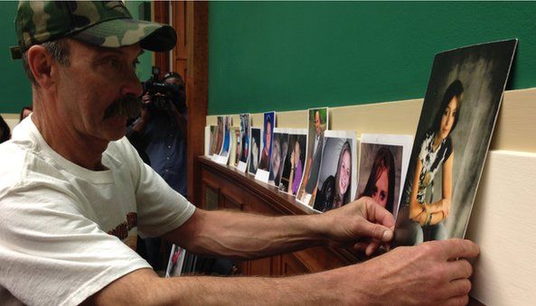Randall Rademaker placing picture of daughter Amy on wall in Congressional hearing
