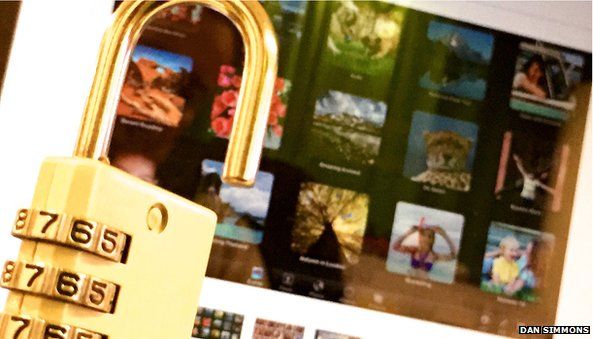 An open padlock sits in front of a Mac displaying photos
